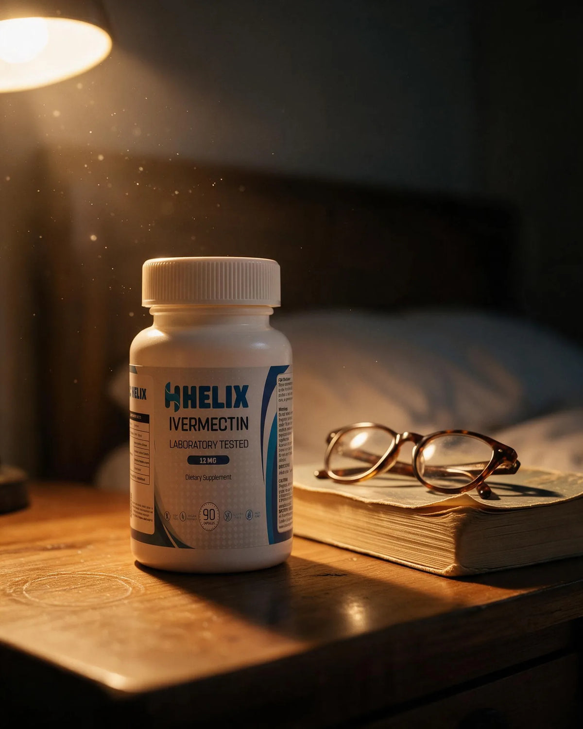 The bottle on a bedside table beside a glass of water and a paperback